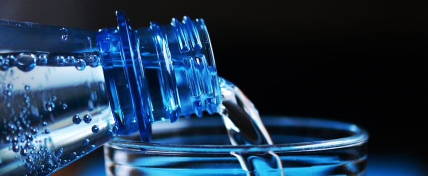 pouring bottled water on a glass