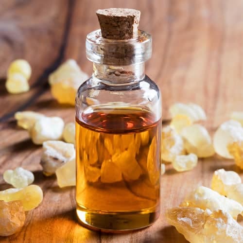 Frankincense resins, essential oil bottle in a wooden background