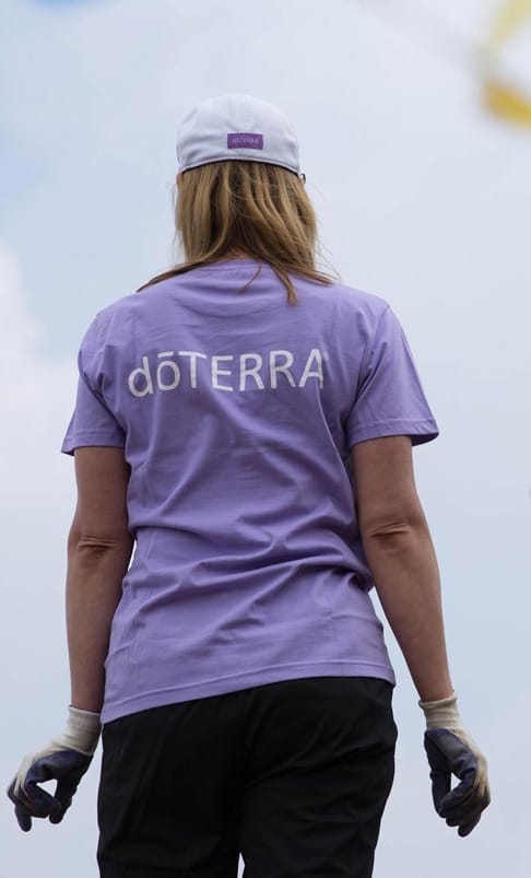 A girls back view she is wearing purple shirt printed doTERRA.