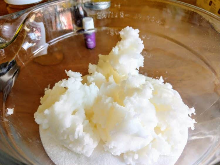 Cup of coconut oil in a bowl, in wooden table