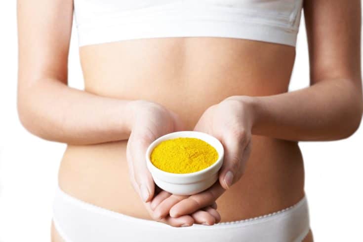 Close Up Of Woman In Underwear Holding Dish Of Tumeric