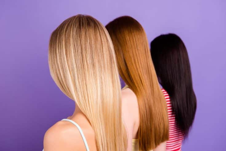 Rear view portrait of trio with different hair color after haircut in beauty salon isolated on vivid violet background. Hair treatment therapy concept