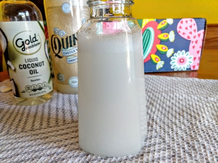 glass bottle with liquid soap, coconut oil, castile on the table