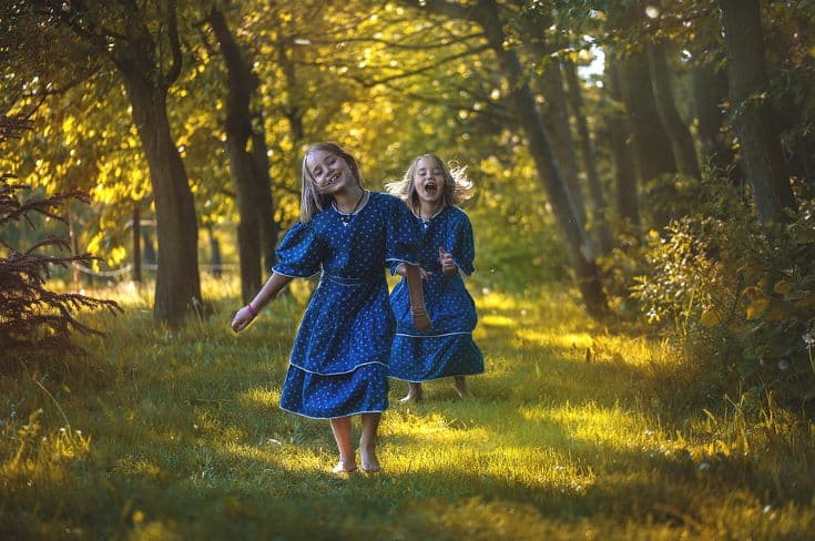 2 girls having fun walking barefoot on the grass