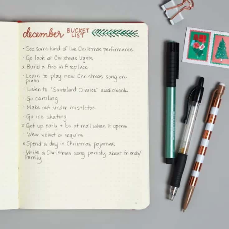 Christmas Holiday Bucket List notebook with pens, stamps and clip in white background