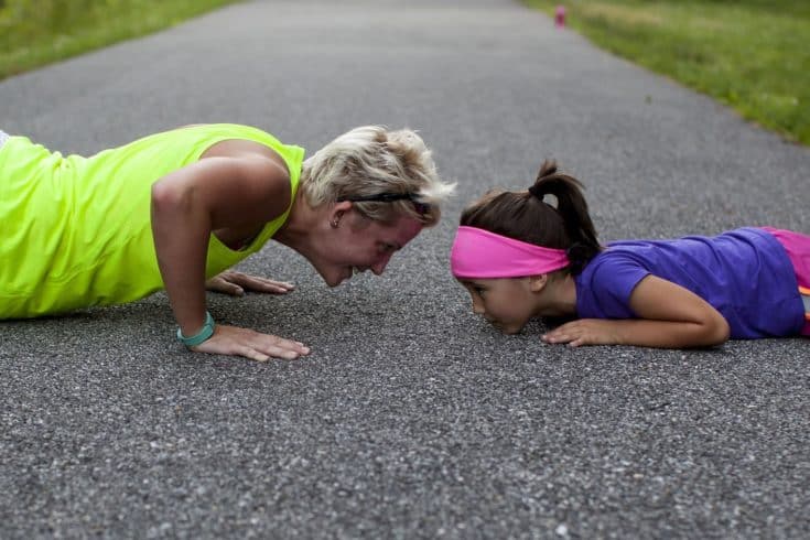 Mother demonstrating push upon her daughter on a cleared road.